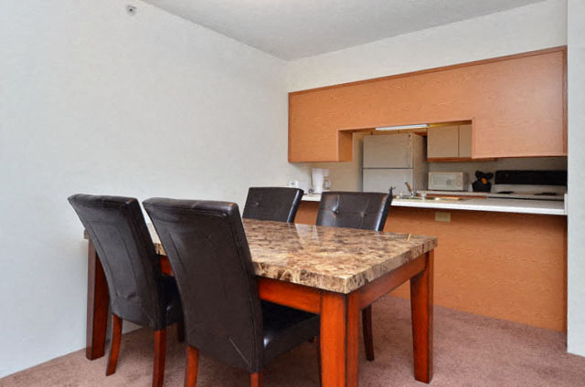 A kitchen with a table and chairs in the foreground.