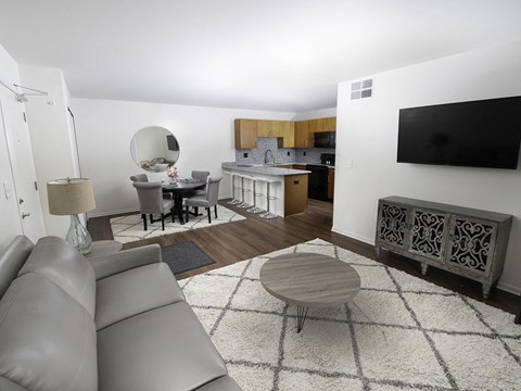 A living room with a grey couch and a wooden coffee table.