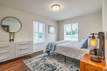 a bedroom with a bed and a dresser and a mirror