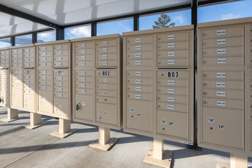 A series of mailboxes are lined up outside in the sunshine.