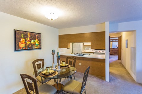 A dining room with a table set for four.