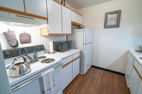 a kitchen with white appliances and white cabinets and a white refrigerator