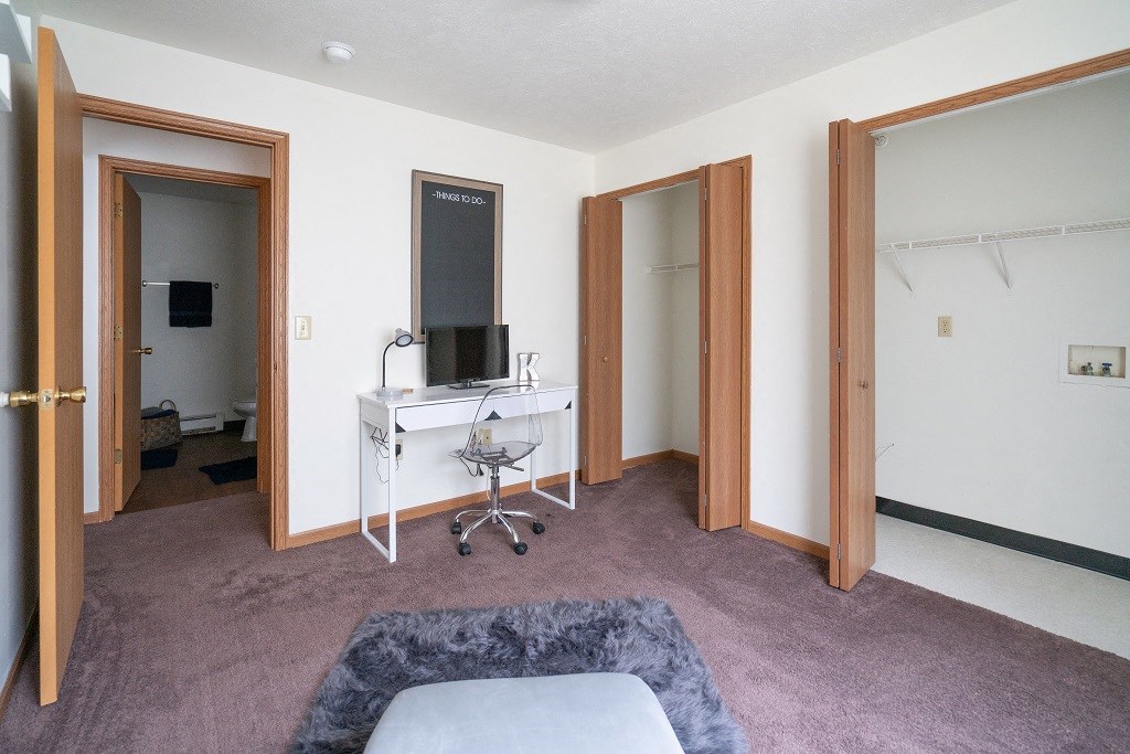 a living room with a couch and a desk with a mirror