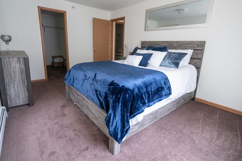 a bedroom with a bed and a dresser and a mirror