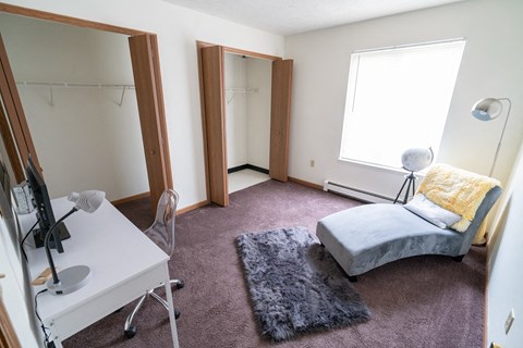 a bedroom with a bed and a desk and a mirror