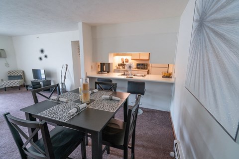 a dining room and living room with a table and chairs and a kitchen