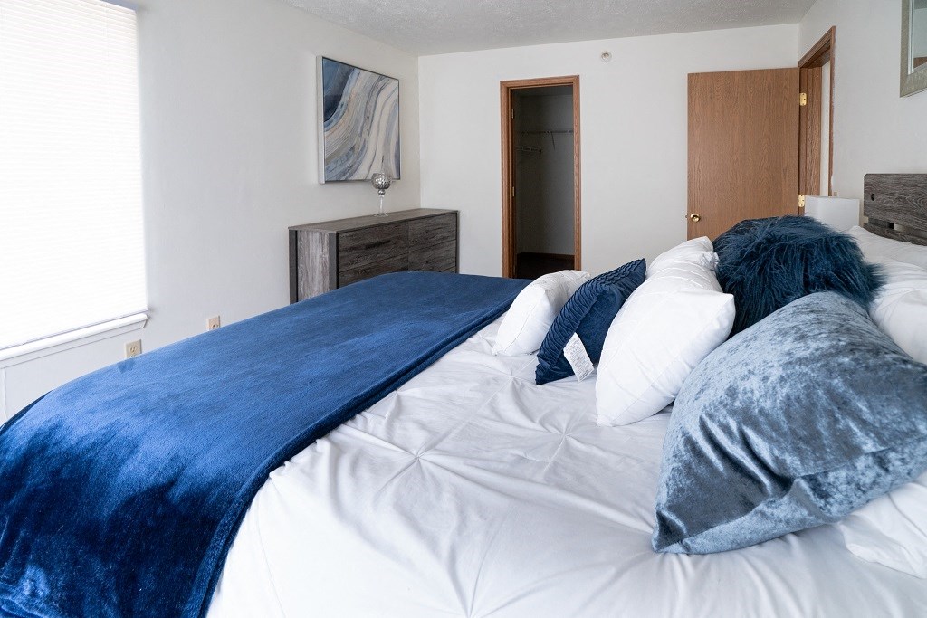 a bedroom with a bed with blue blankets and pillows