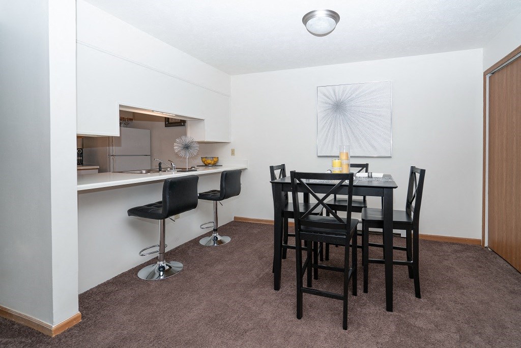 a dining room with a table and chairs and a kitchen
