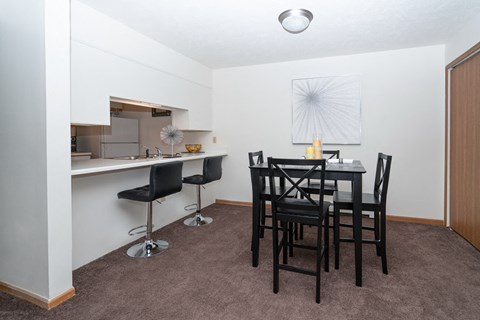 a dining room with a table and chairs and a kitchen