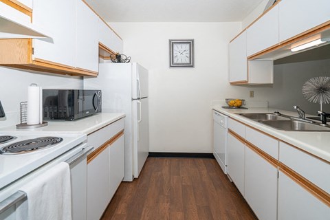 a kitchen with white cabinets and a sink and a refrigerator