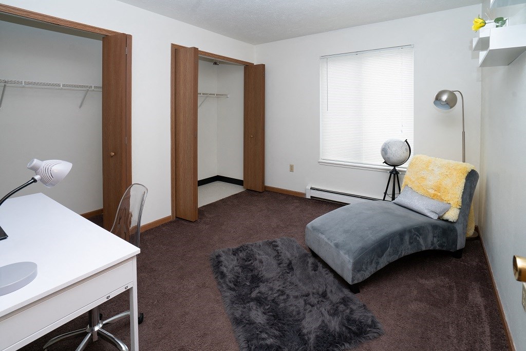 a bedroom with a bed and a desk and a mirror