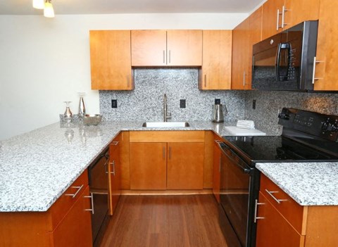 A kitchen with wooden cabinets and granite countertops.