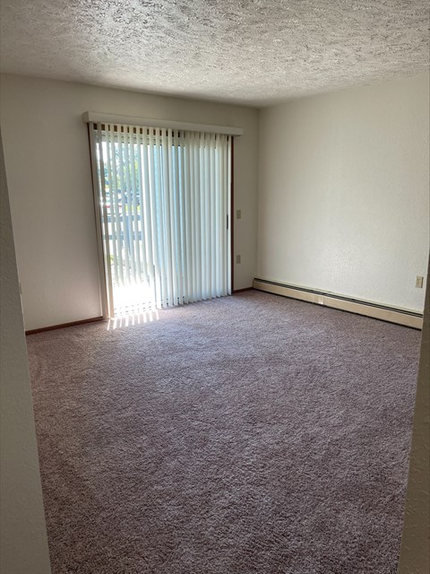 an empty living room with a sliding glass door