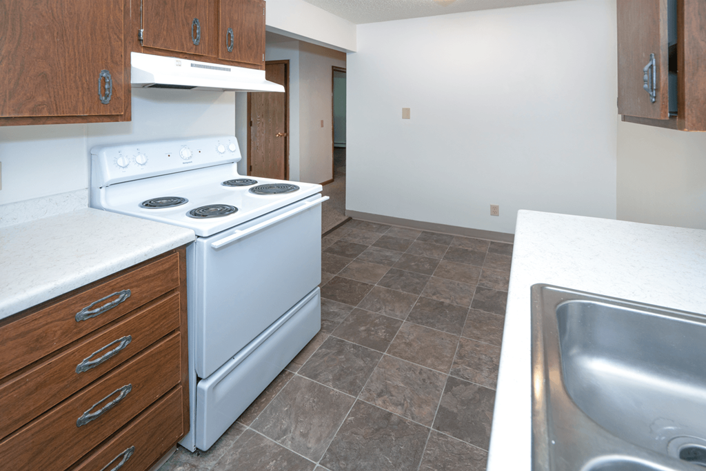 an empty kitchen with a stove and a sink
