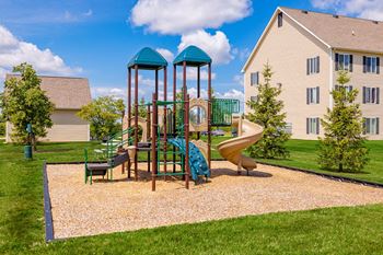 A playground with a slide, swings, and a roundabout.