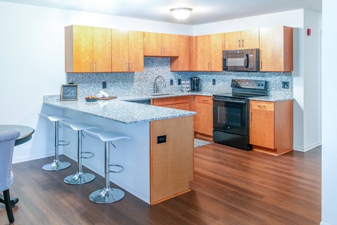 a kitchen with wooden cabinets and a counter top with bar stools