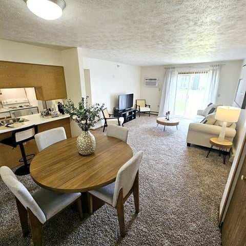 A living room with a dining table and chairs.