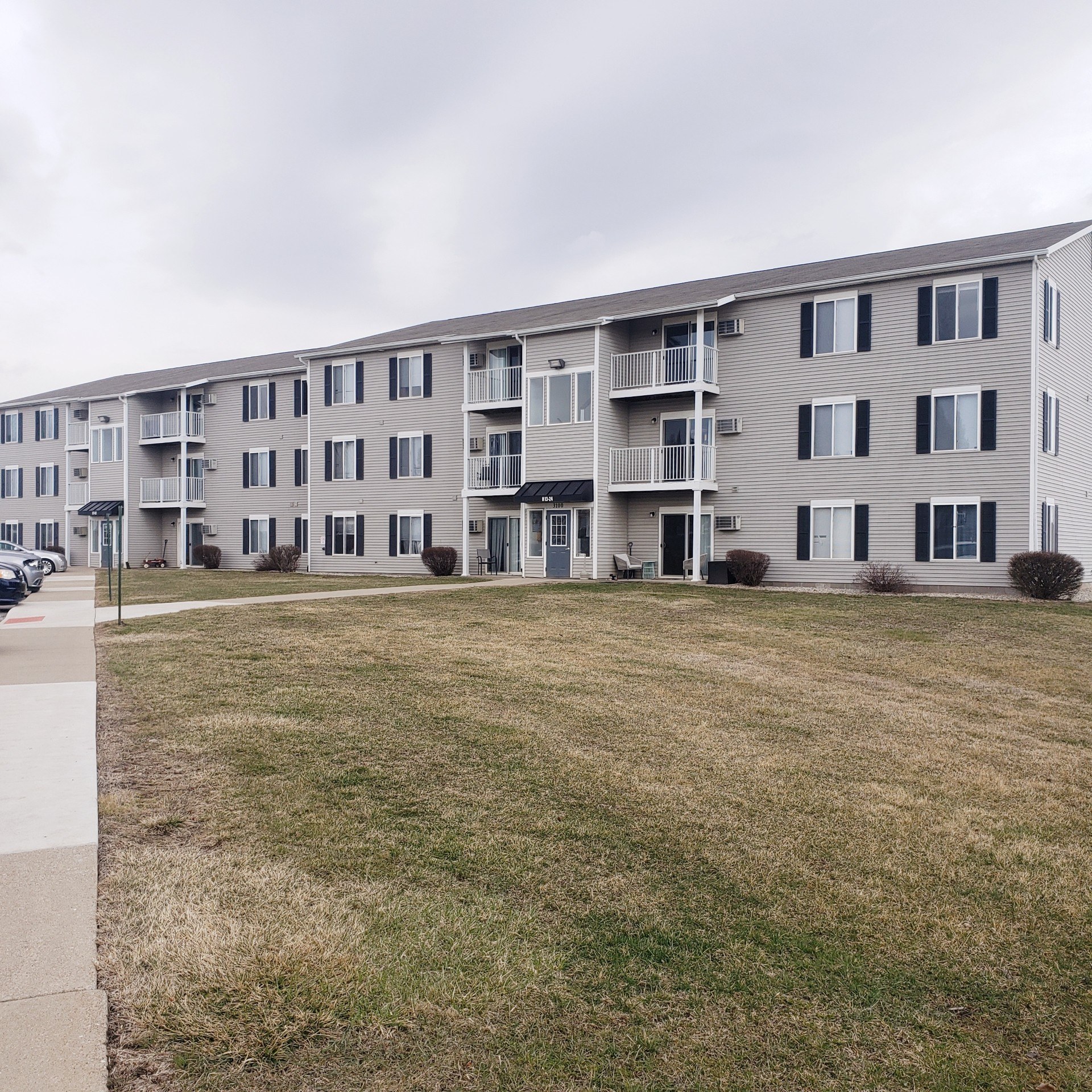 A large apartment building with multiple balconies and doors.