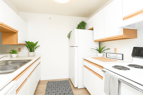 A kitchen with white cabinets and a white fridge.