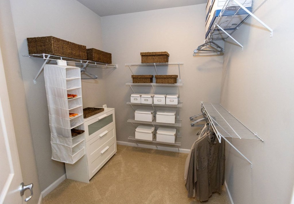 a spacious walk in closet with shelves and baskets