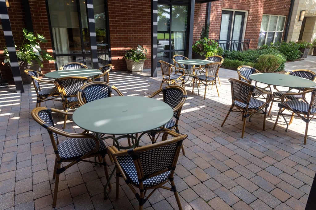 a patio with tables and chairs outside of a building