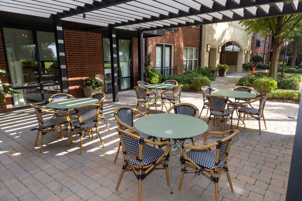 a patio with tables and chairs outside of a building