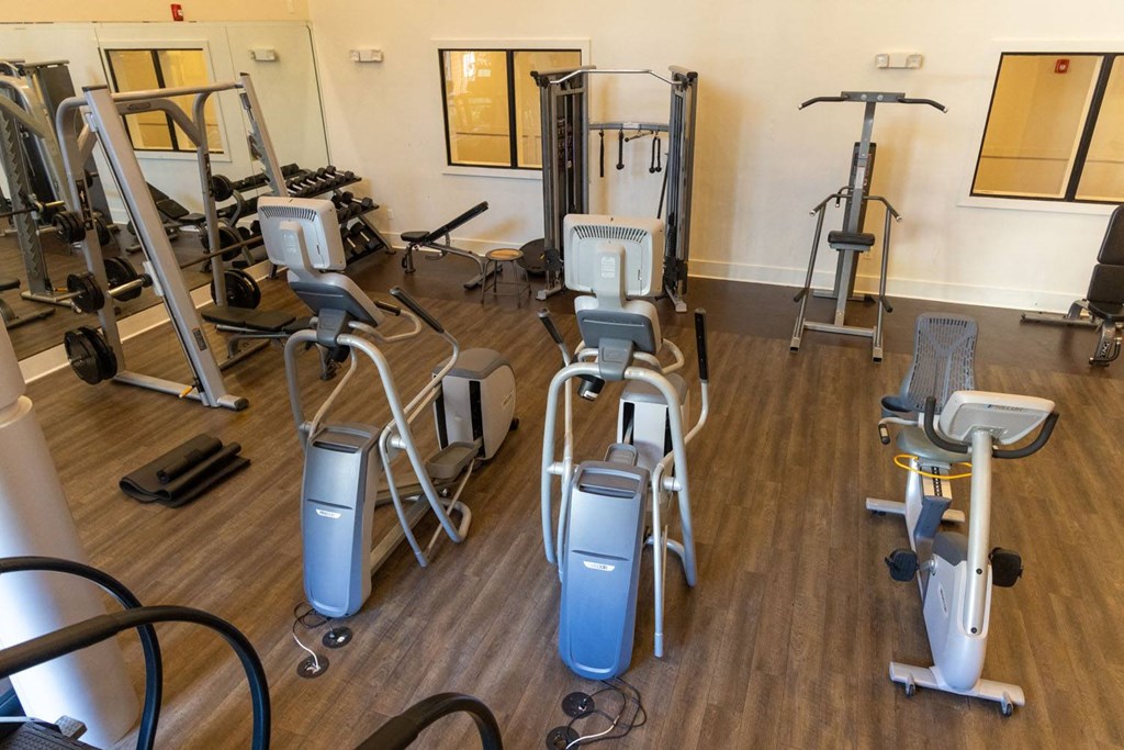 a gym full of exercise equipment on a wooden floor