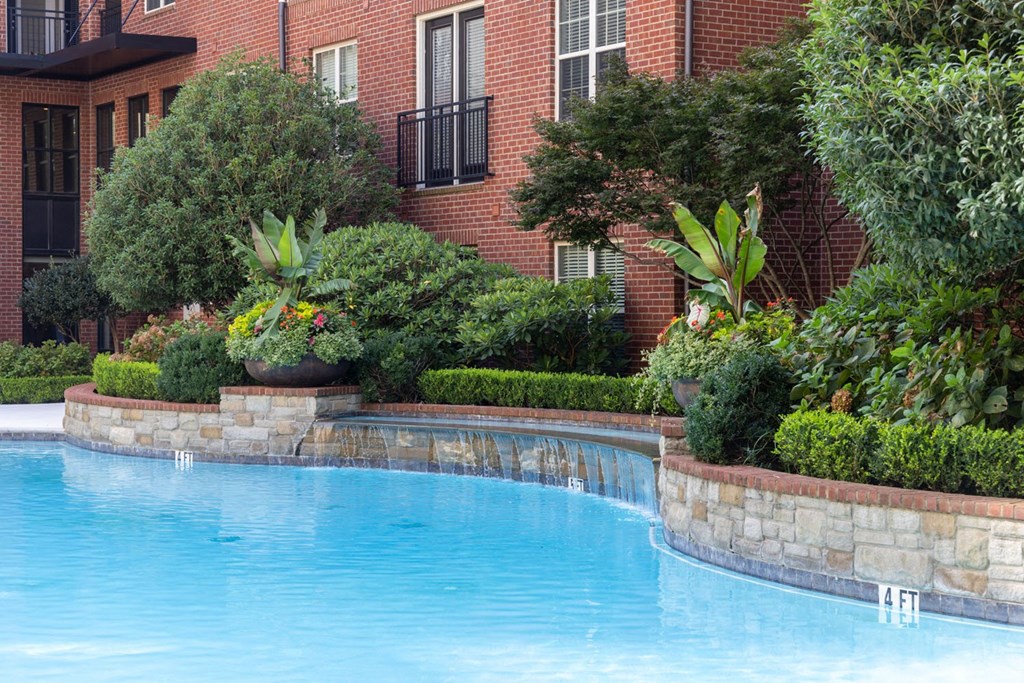 a swimming pool in front of a brick building