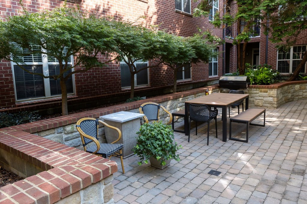 a brick patio with tables and chairs and a fountain