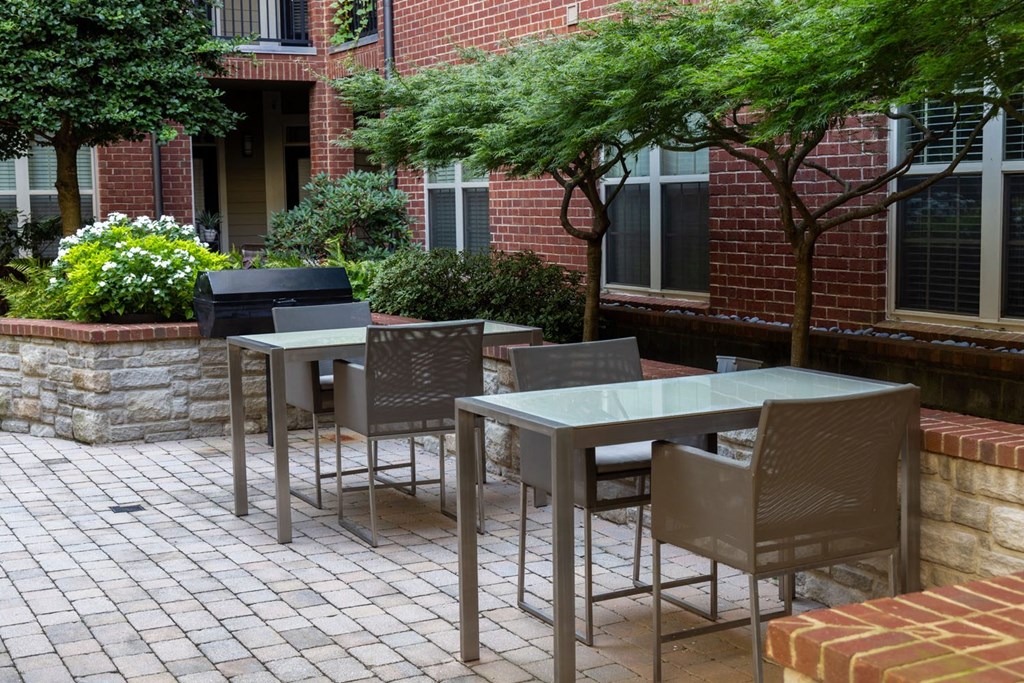 a patio with tables and chairs outside of a brick building