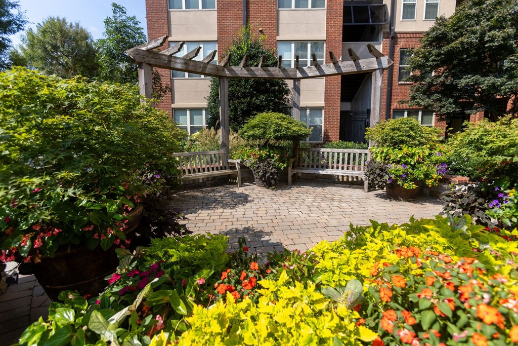a patio with flowers and a building in the background