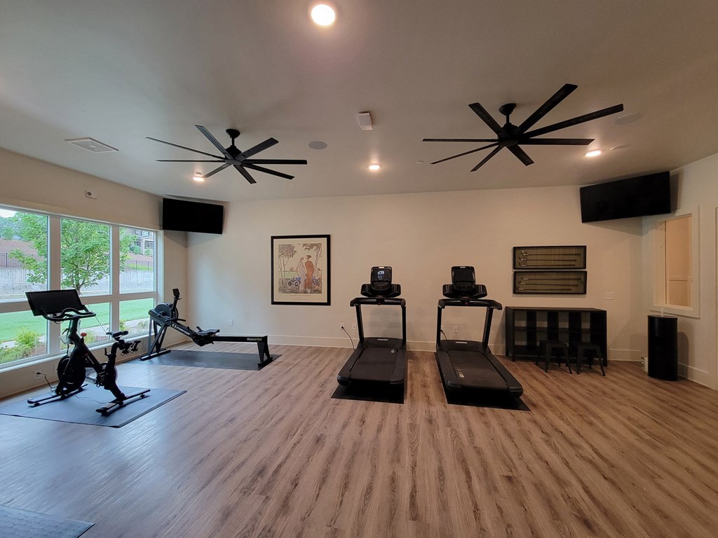 a fitness room with treadmills and other exercise equipment