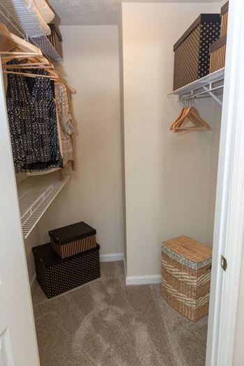 a walk in closet with shelves and baskets