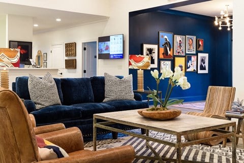 a living room with a blue couch and a table with chairs