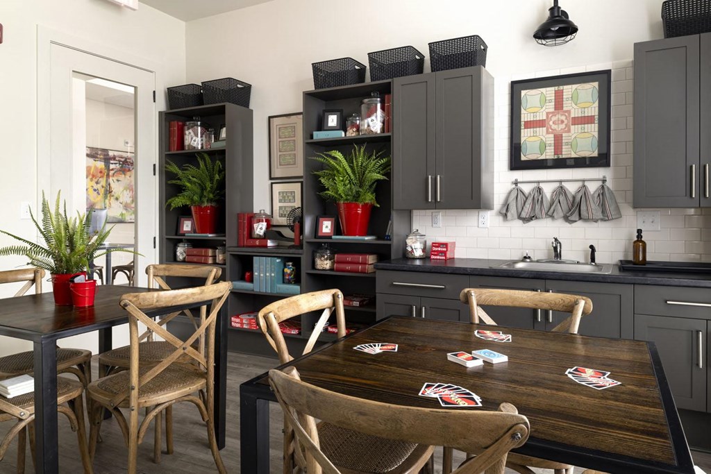a kitchen with gray cabinets and a wooden table and chairs