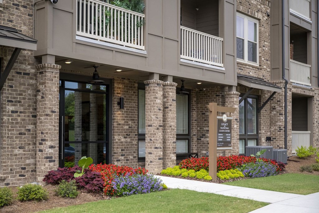 a building with a sign and flowers in front of it