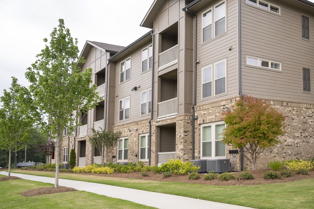 an apartment building with a sidewalk in front of it
