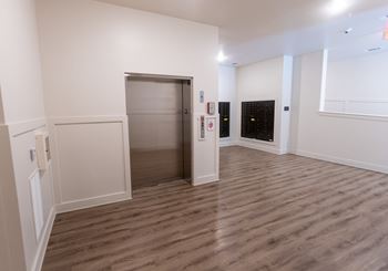 a large empty room with white walls and a stainless steel door