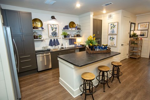 a kitchen with a center island and three stools in front of a kitchen counter