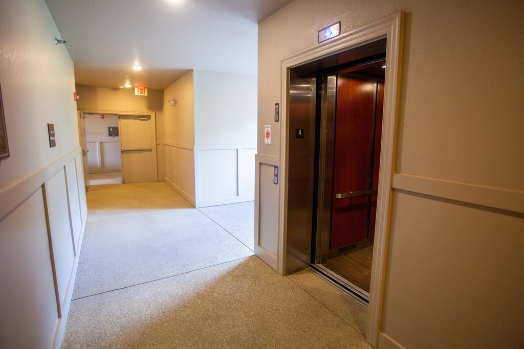 a hallway with a door to a bathroom and a kitchen