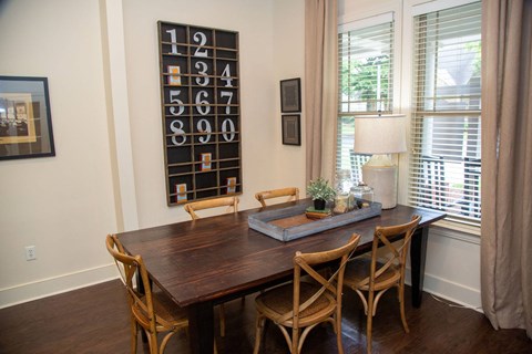 A dining room with a wooden table and chairs.