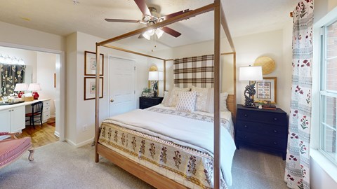A bedroom with a four poster bed and a dresser.