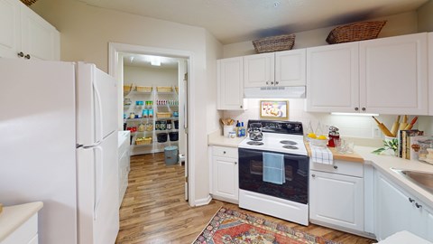 A kitchen with white appliances and cabinets.