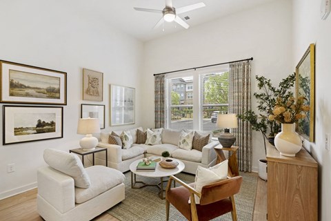 A living room with a white couch, a coffee table, and a painting on the wall.