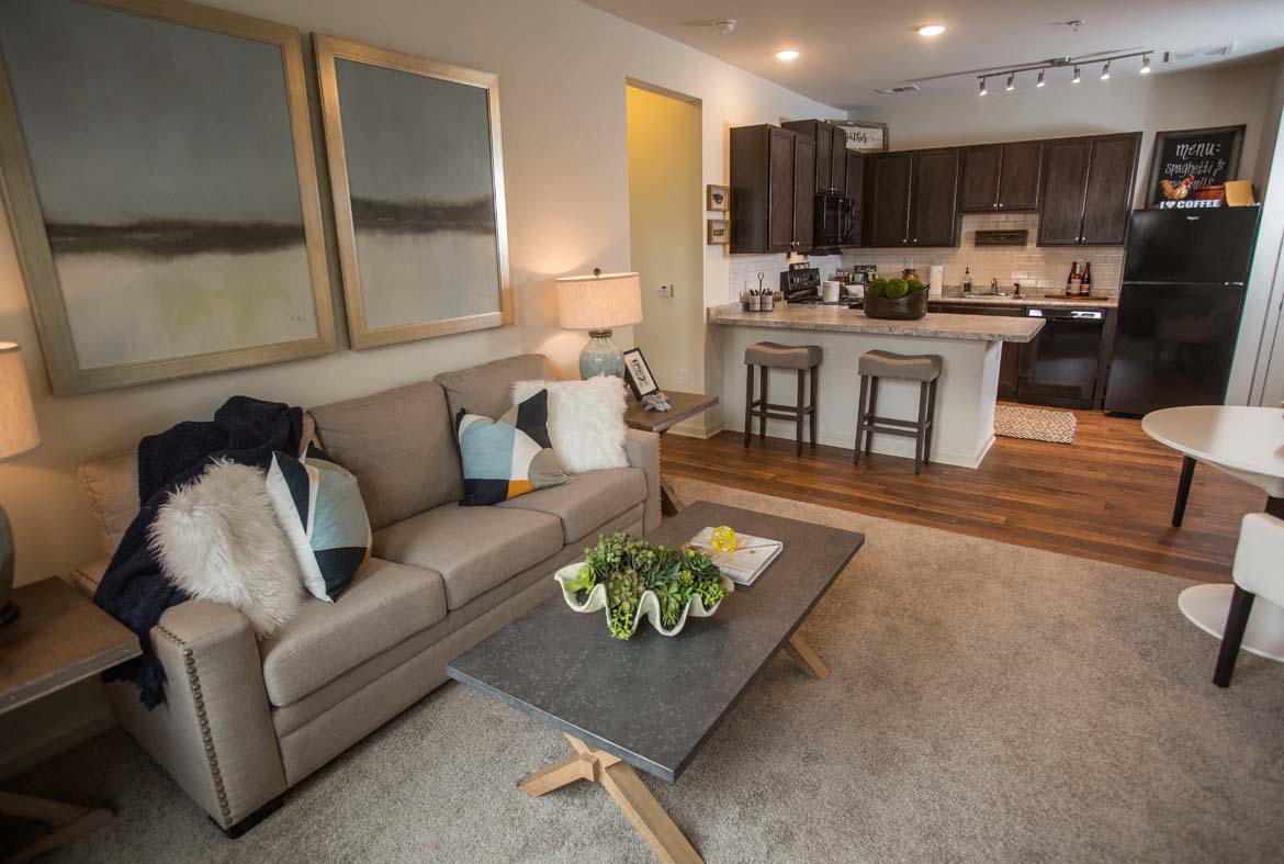 A modern living room with a grey couch and a grey coffee table.