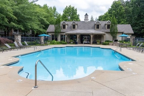 a resort style pool with a house in the background