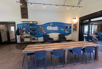 a dining room with a table and chairs and a mural on the wall