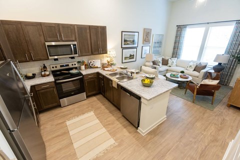 A kitchen with a refrigerator, oven, and sink.