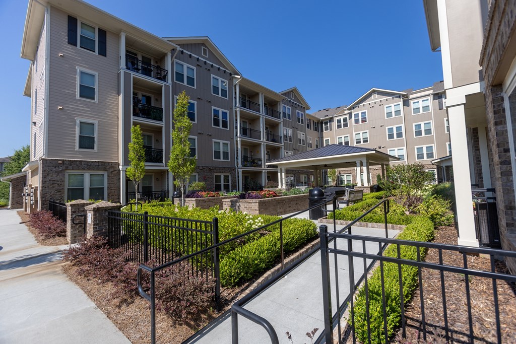 an apartment complex with a walkway and steps leading up to the entrance