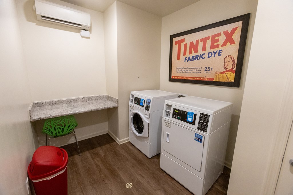 a laundry room with two washers and a dryer